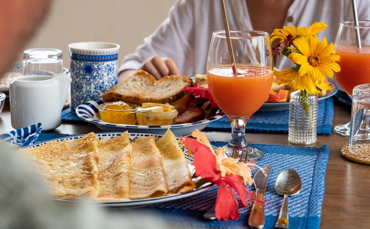 Orange juice, toast and flowers on the blue cloth