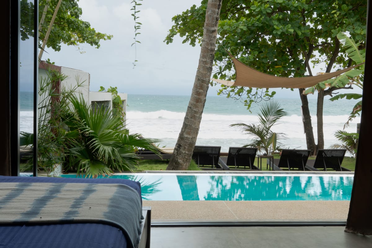 The bed opening onto the infinity pool and the ocean